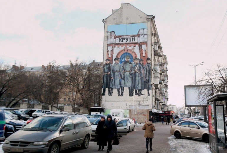 У Києві про героїв Крут нагадує мурал біля палацу культури "Україна". 

